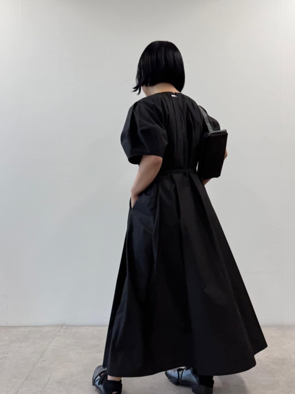 ブラック系のワンピース、ブラック系のボディバッグ/ウエストポーチを着用したレディースの春コーディネートの2枚目の写真