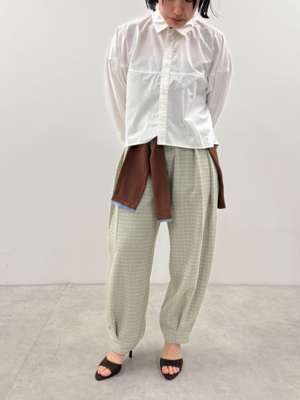 ブラウン系のカーディガン/ボレロ、ブルー系のその他パンツ、ホワイト系のシャツ/ブラウスを着用したレディースの春コーディネートの3枚目の写真