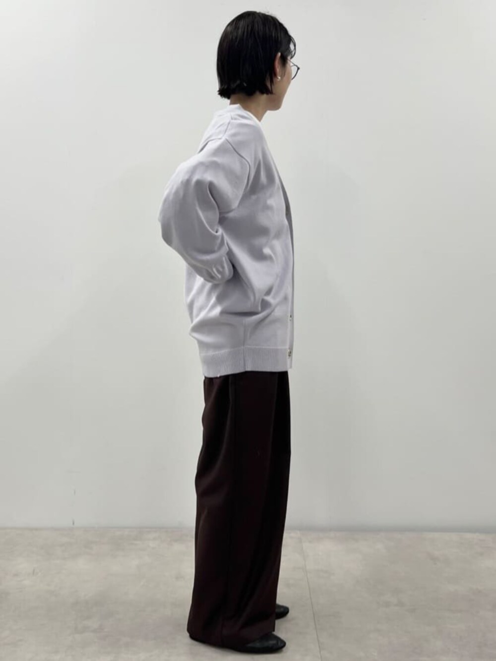 パープル系のカーディガン/ボレロ、ブラウン系のスラックスを着用したレディースの秋コーディネートの2枚目の写真