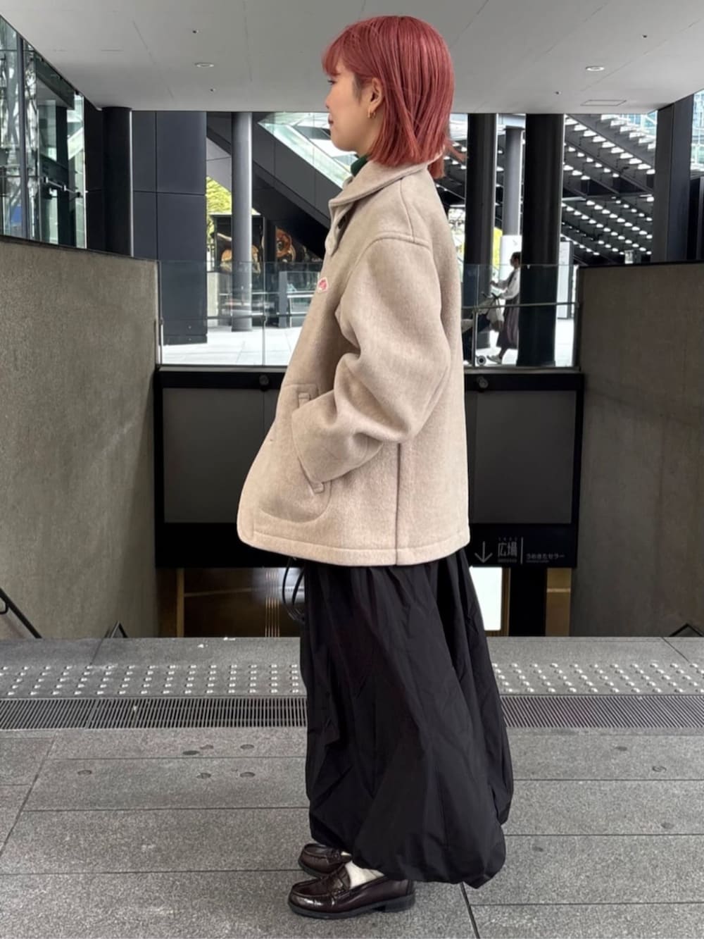 ブラック系のスカート、ブラック系のハンドバッグを着用したレディースの秋コーディネートの2枚目の写真