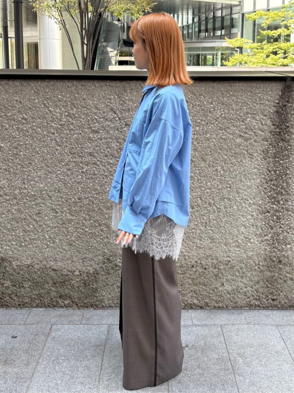 ブルー系のシャツ/ブラウス、グレー系のスラックスを着用したレディースの秋コーディネートの2枚目の写真