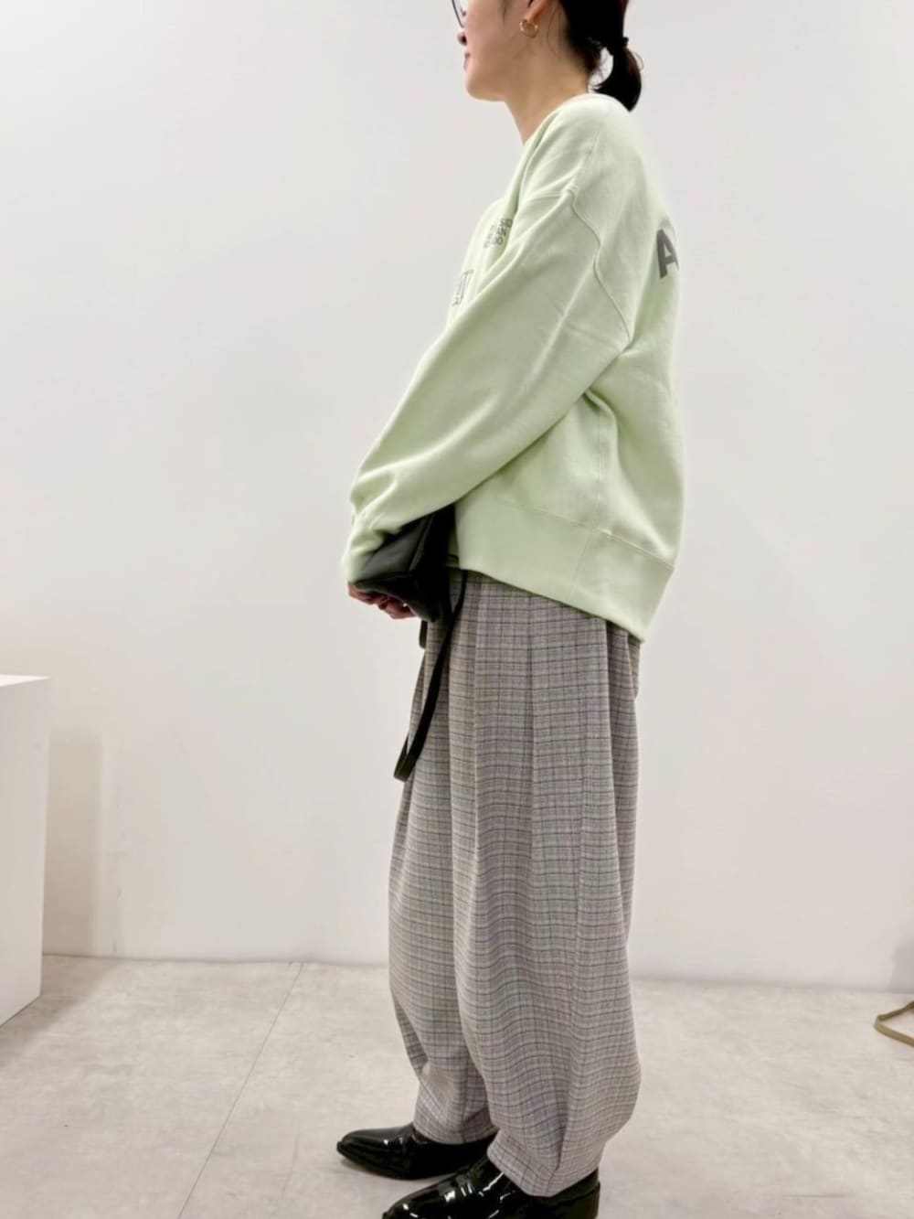 ブラック系のローファー、ブルー系のスウェット、ブラック系のショルダーバッグを着用したレディースの冬コーディネートの2枚目の写真