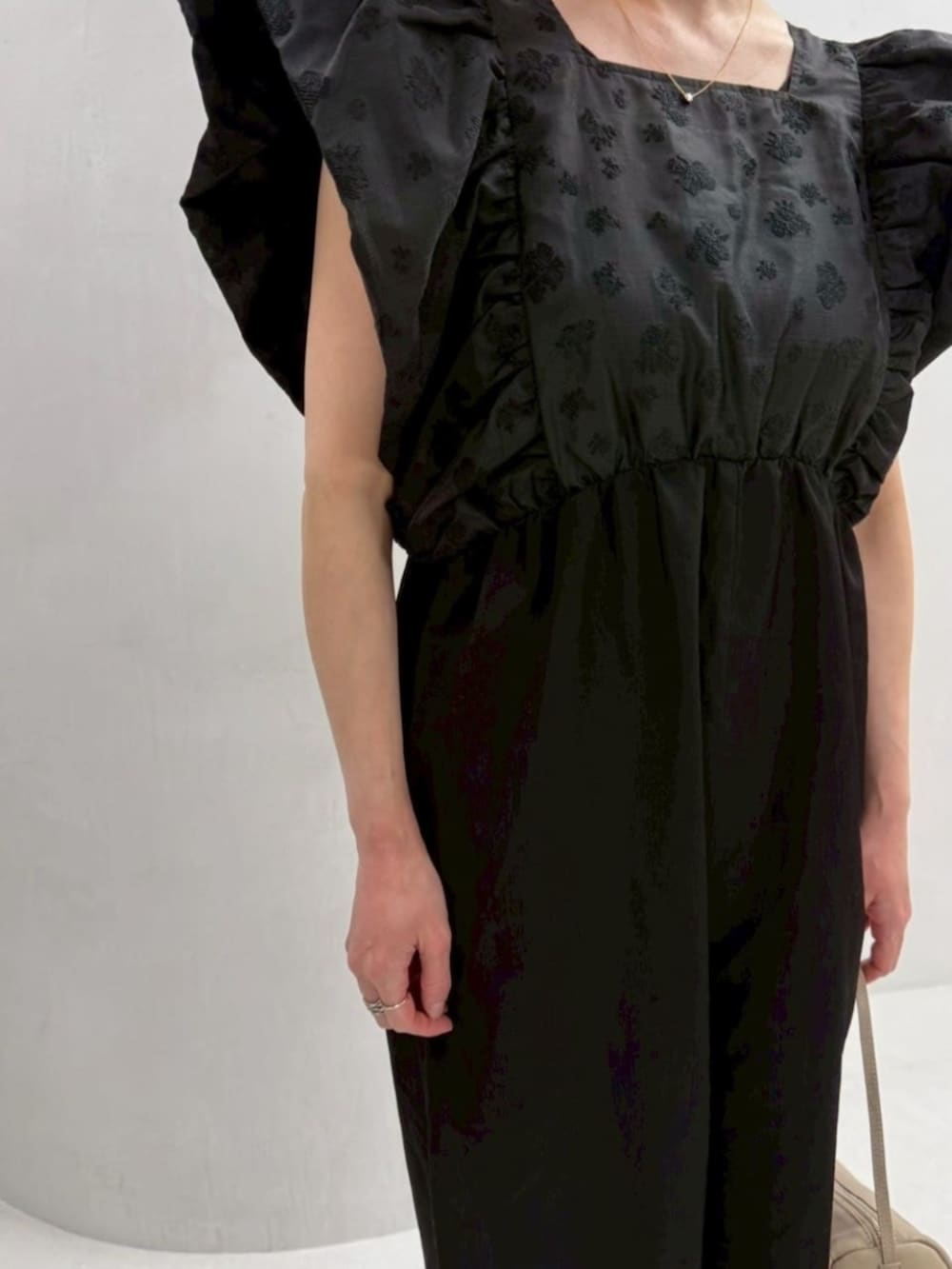 ベージュ系のボストンバッグ、ブラック系のつなぎ/オールインワンを着用したレディースの冬コーディネートの5枚目の写真