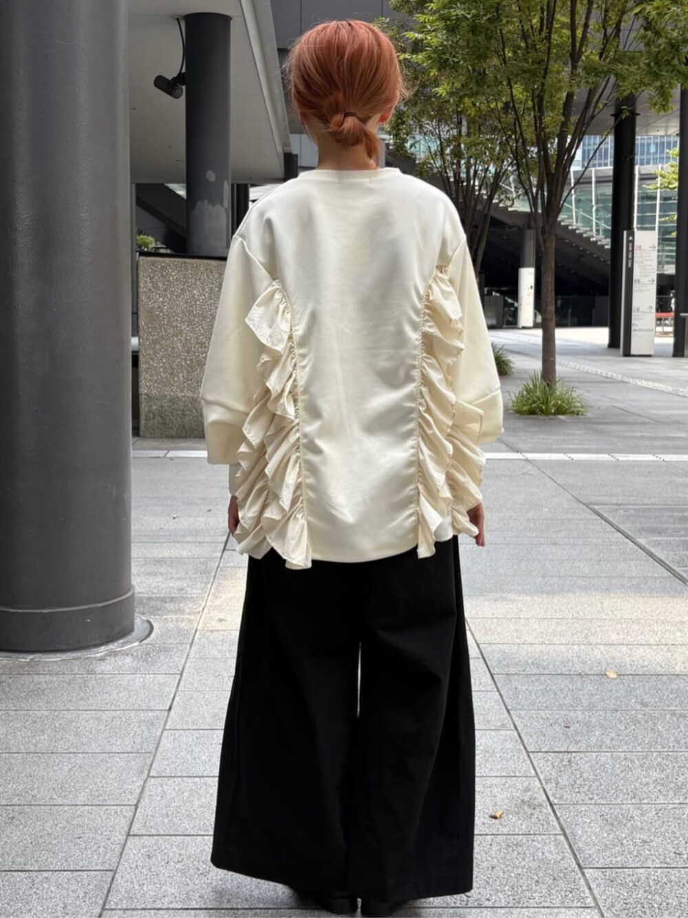 ホワイト系のスウェット、ブラック系のチノパンツを着用したレディースの秋コーディネートの3枚目の写真