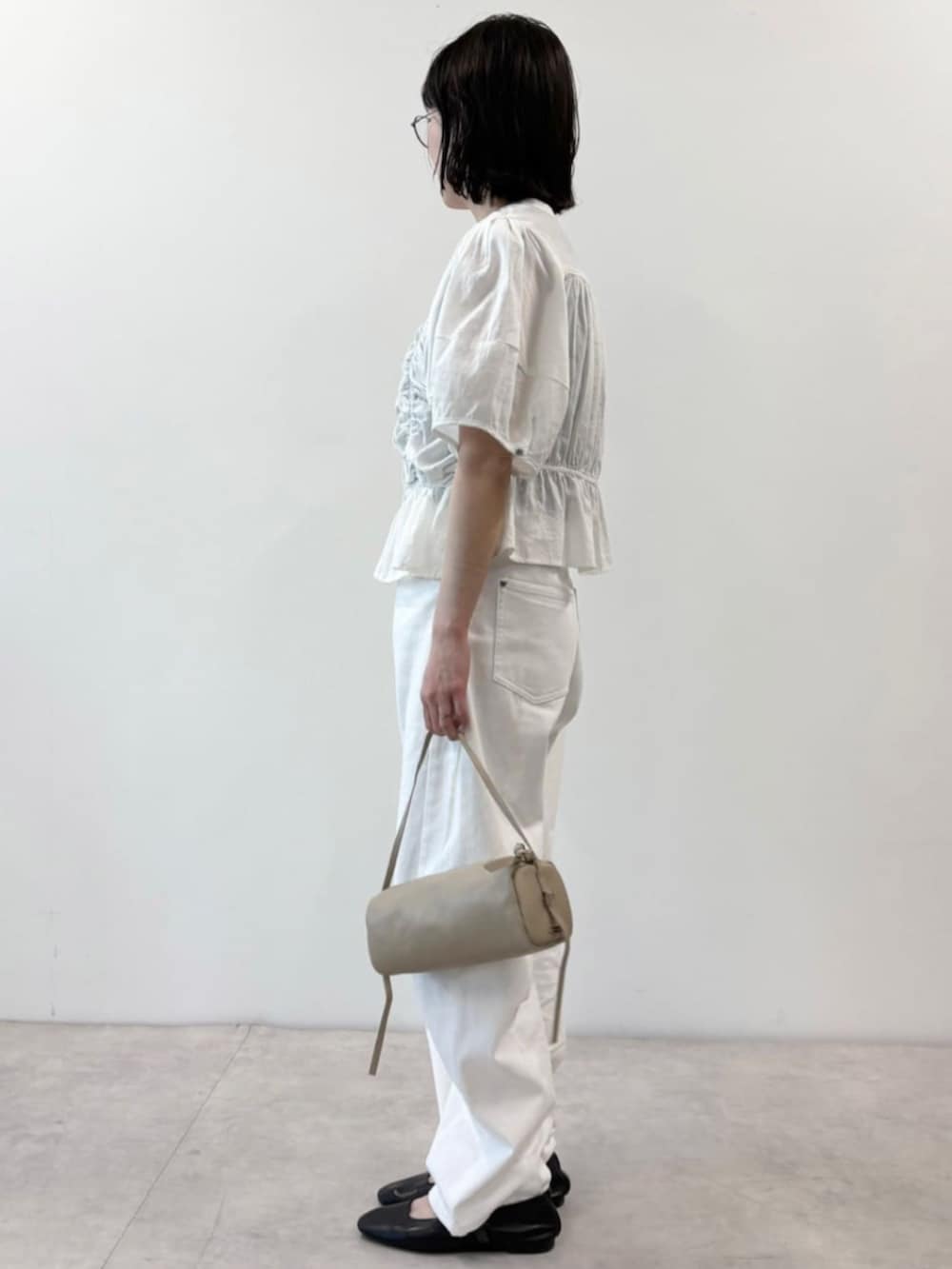 ベージュ系のボストンバッグ、ホワイト系のデニムパンツ、ホワイト系のシャツ/ブラウスを着用したレディースの春コーディネートの2枚目の写真