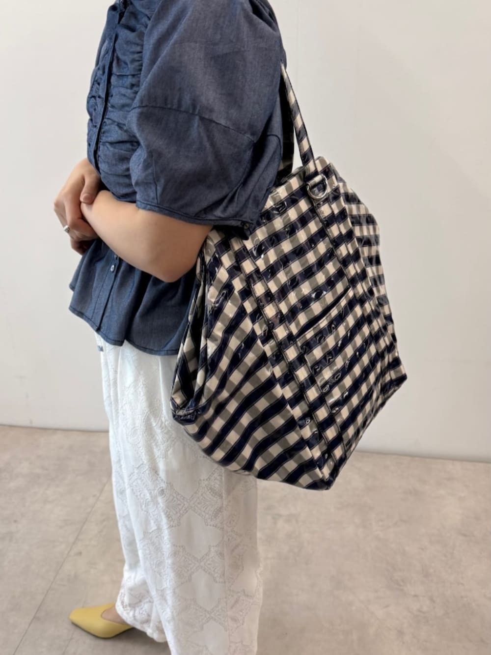 ブルー系のシャツ/ブラウス、ブルー系のトートバッグ、ホワイト系のデニムパンツを着用したレディースの春コーディネートの3枚目の写真