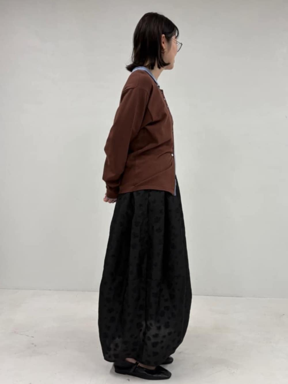 ブラウン系のカーディガン/ボレロ、ブラック系のスカートを着用したレディースの冬コーディネートの4枚目の写真