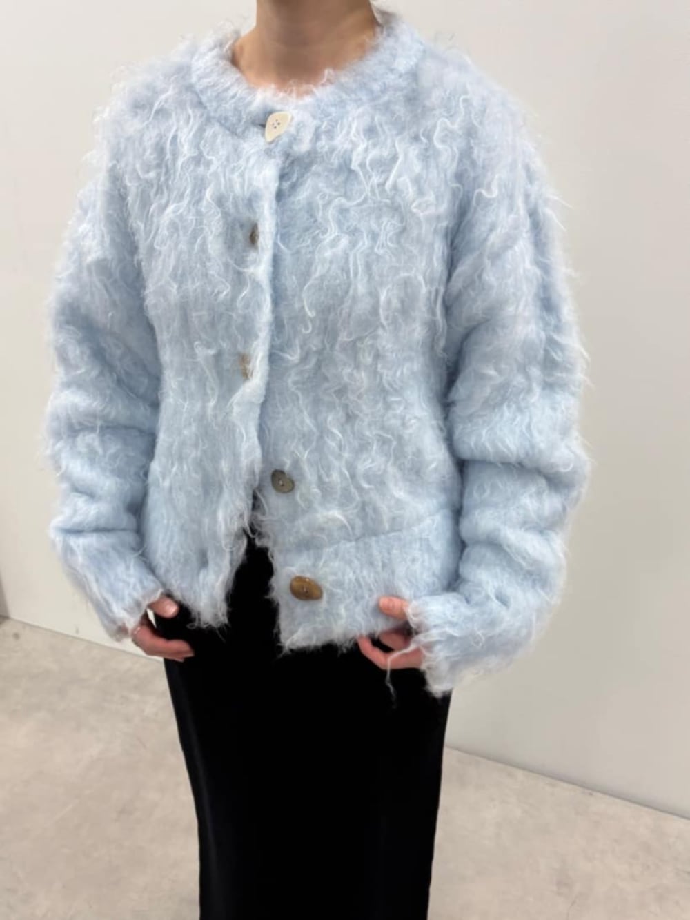 ブルー系のカーディガン/ボレロ、ブラック系のスカート、ブラック系のローファーを着用したレディースの秋コーディネートの4枚目の写真