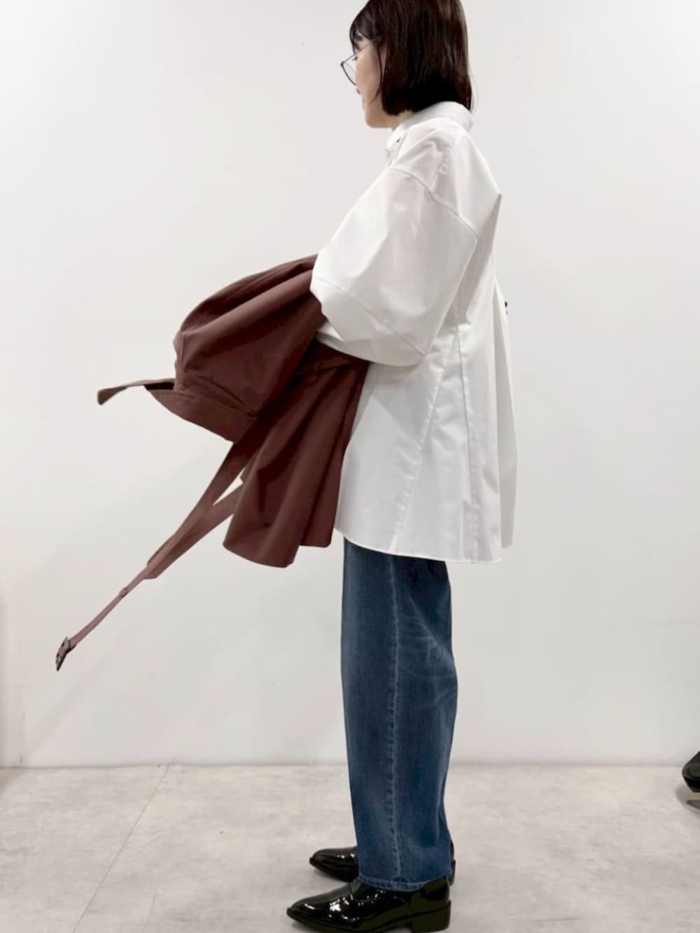 ブラック系のローファー、ホワイト系のシャツ/ブラウス、ブラック系のボストンバッグを着用したレディースの冬コーディネートの3枚目の写真