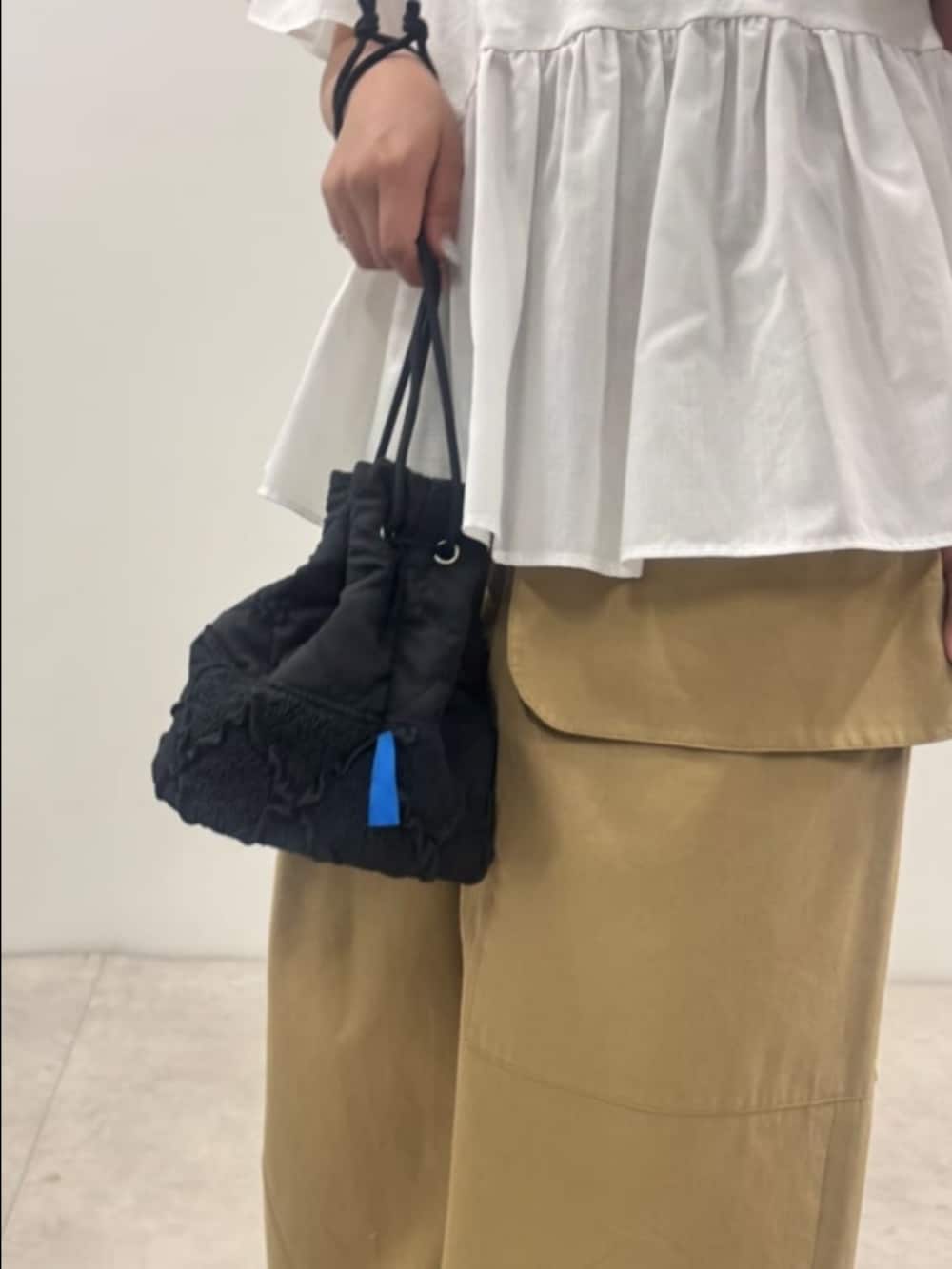ホワイト系のTシャツ/カットソー、イエロー系のチノパンツ、ブラック系のハンドバッグを着用したレディースの夏コーディネートの3枚目の写真