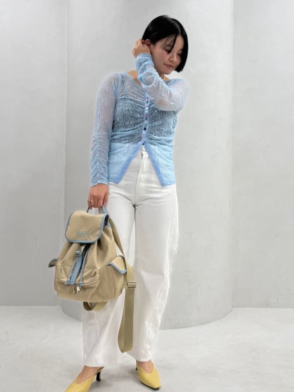 ブルー系のニット/セーター、ベージュ系のバックパック/リュックを着用したレディースの冬コーディネートの2枚目の写真
