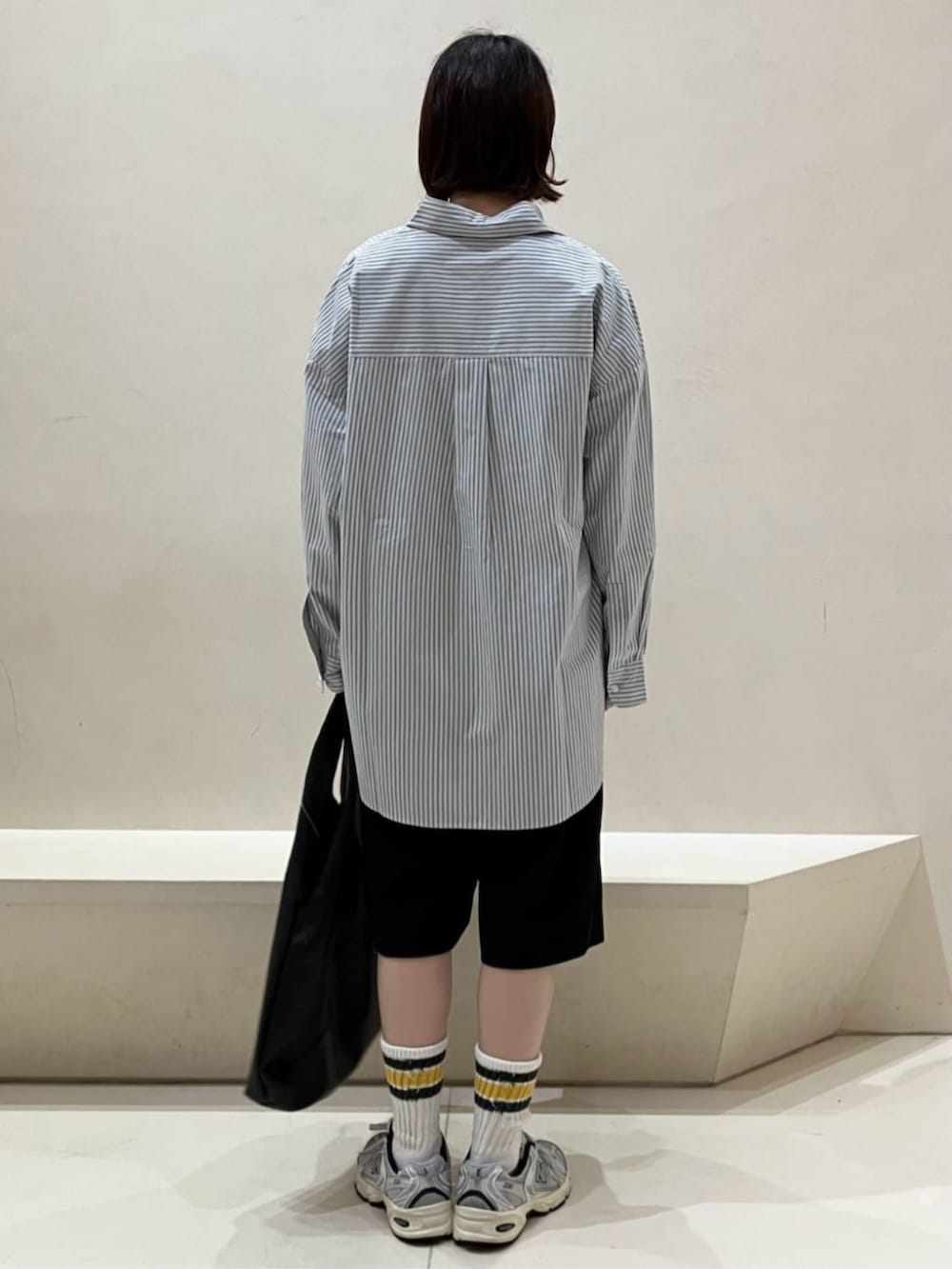 ブラック系のその他パンツ、ブラック系のトートバッグ、ブルー系のシャツ/ブラウスを着用したレディースの秋コーディネートの3枚目の写真