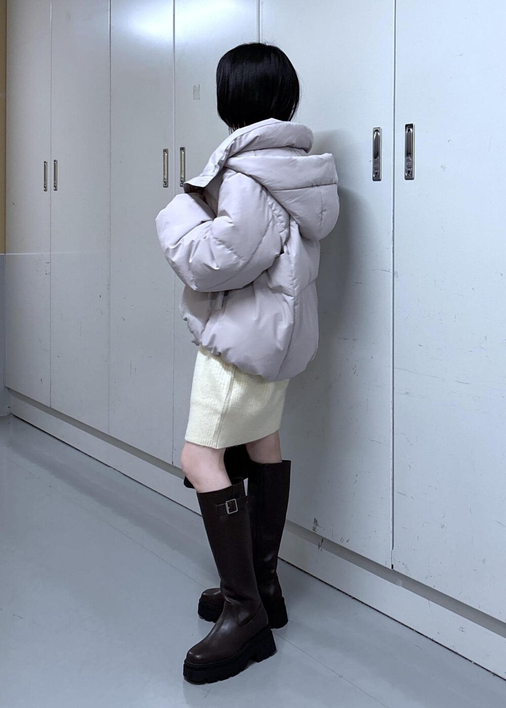 ピンク系のダウンジャケット/コート、ブラウン系のブーツ、ホワイト系のワンピースを着用したレディースの冬コーディネートの5枚目の写真