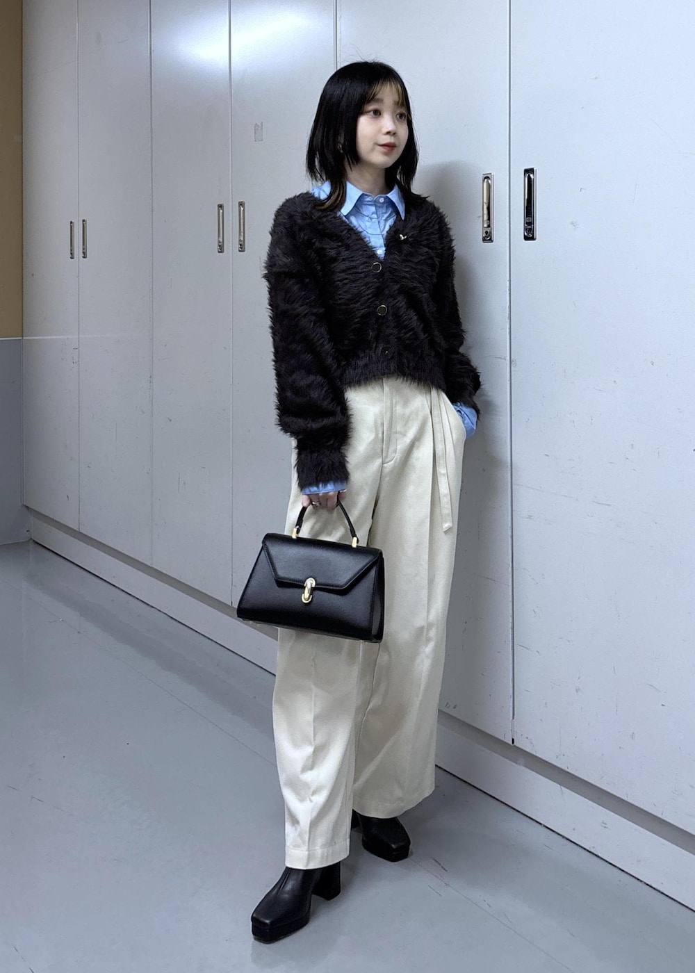 グレー系のカーディガン/ボレロ、グレー系のブルゾン、ブラック系のブーツを着用したレディースの冬コーディネートの2枚目の写真