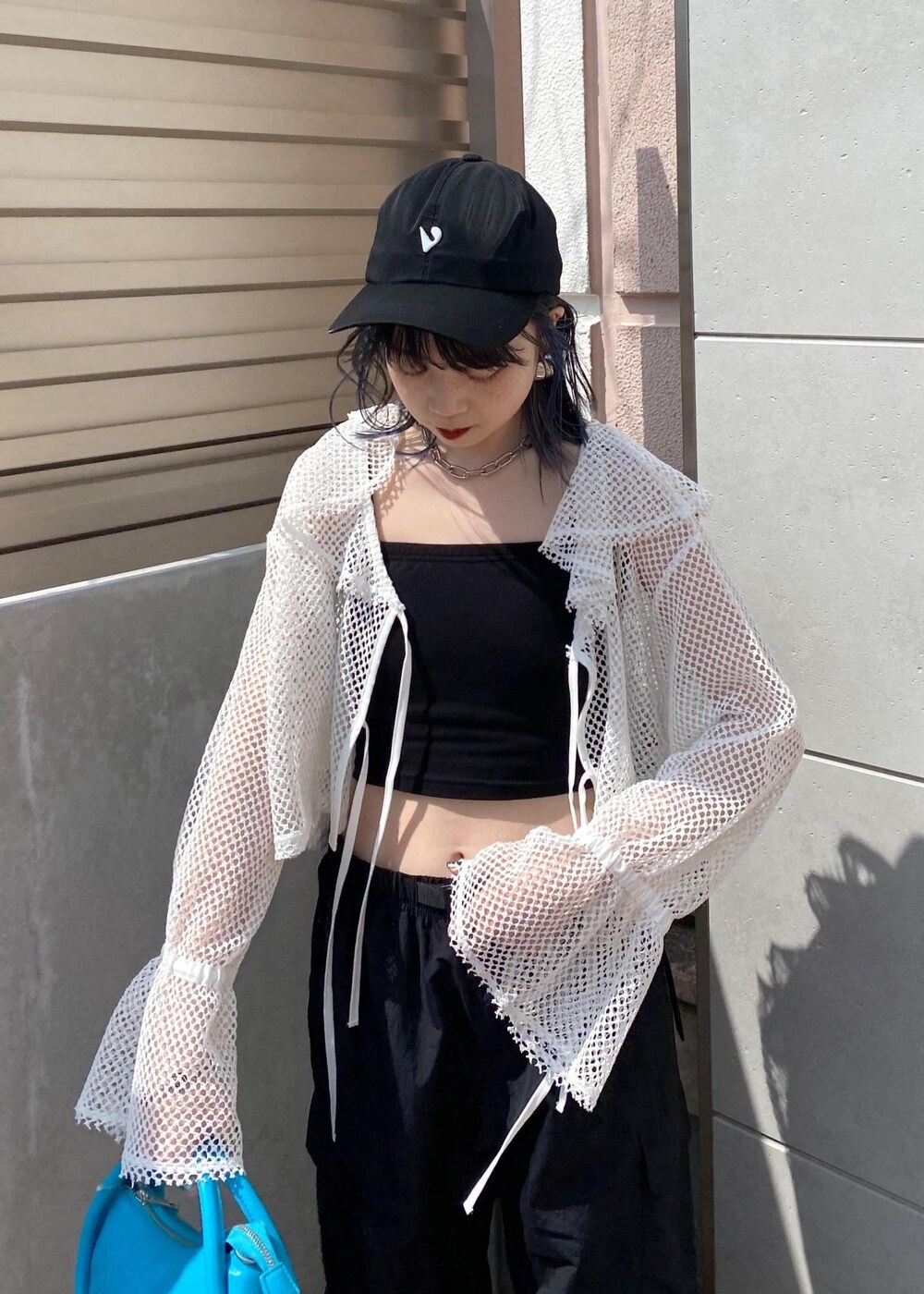 シルバー系のその他シューズ、ブラック系のカーゴパンツ、ブルー系のショルダーバッグを着用したレディースの春コーディネートの3枚目の写真