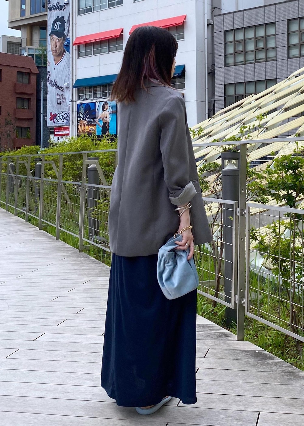ブルー系のハンドバッグ、ブルー系のワンピース、ブルー系のサンダルを着用したレディースの夏コーディネートの4枚目の写真