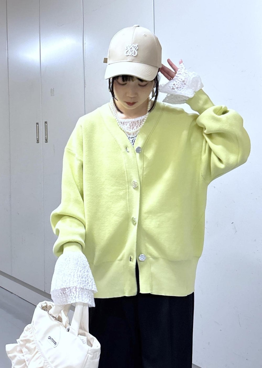 ブルー系のその他パンツ、グリーン系のカーディガン/ボレロ、ホワイト系のトートバッグを着用したレディースの冬コーディネートの5枚目の写真