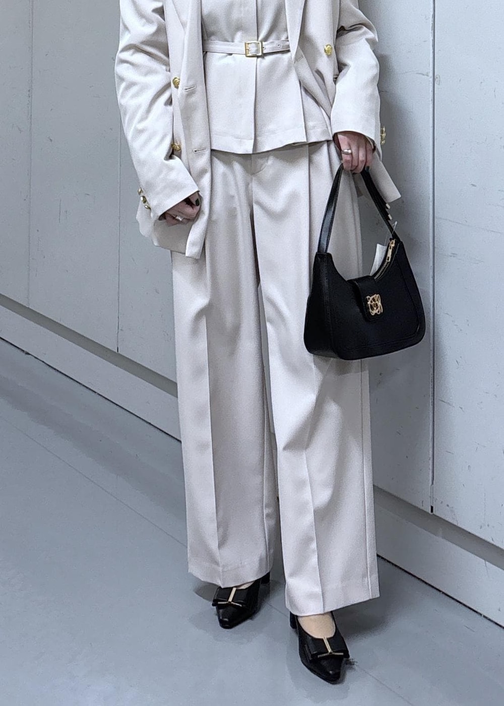 ブラック系のショルダーバッグ、ブラック系のパンプス、ベージュ系のその他パンツを着用したレディースの冬コーディネートの6枚目の写真