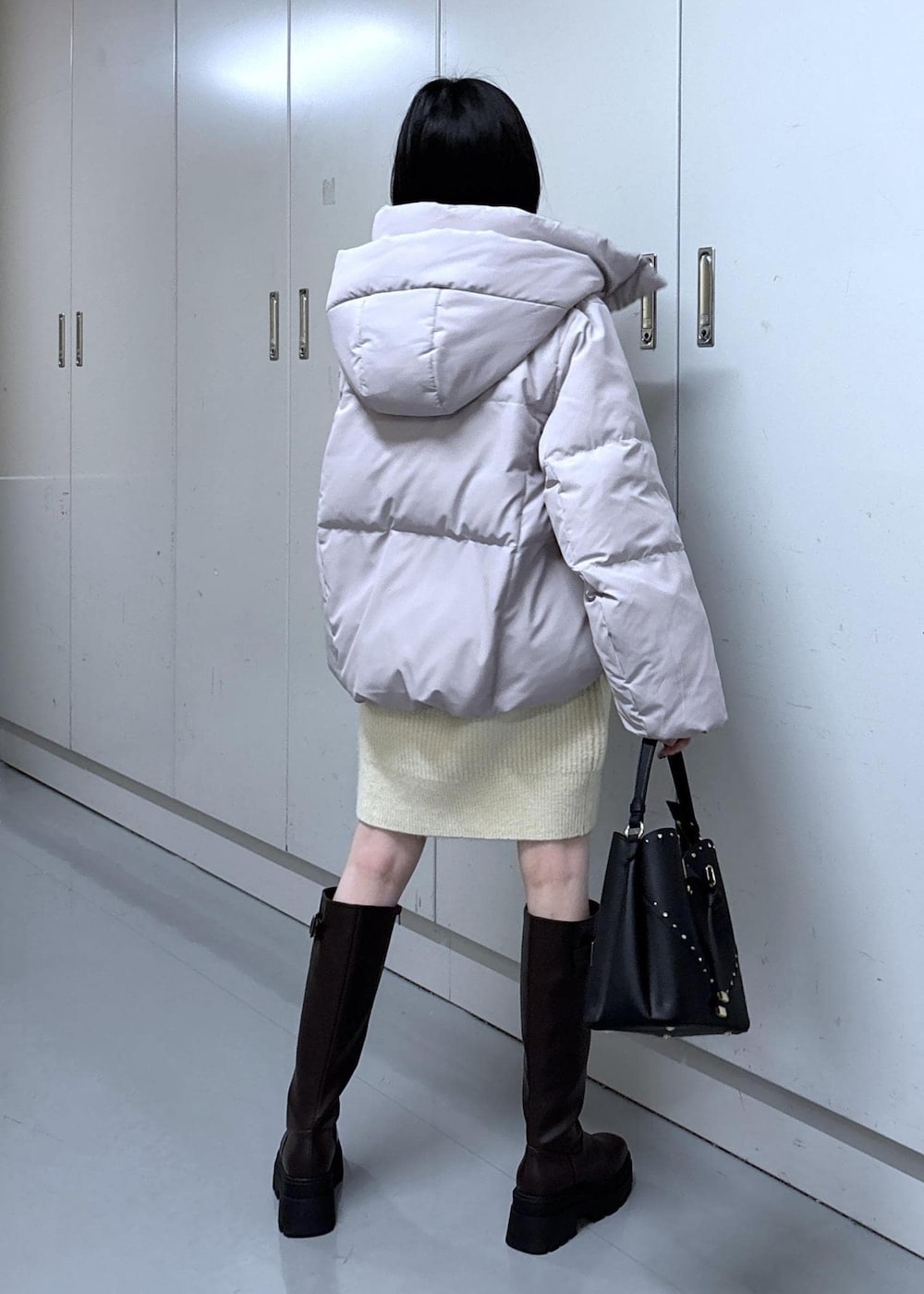 ピンク系のダウンジャケット/コート、ブラウン系のブーツ、ホワイト系のワンピースを着用したレディースの冬コーディネートの4枚目の写真