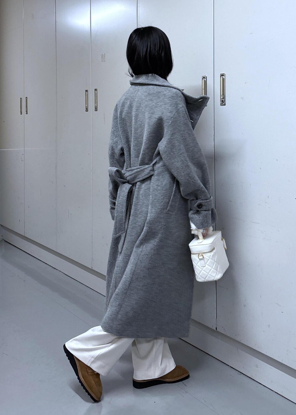 ベージュ系のローファー、グレー系のその他アウター、ホワイト系のハンドバッグを着用したレディースの冬コーディネートの2枚目の写真