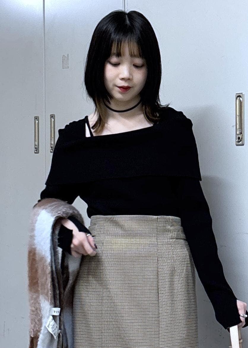 ベージュ系のショルダーバッグ、ベージュ系のスカート、ブラック系のニット/セーターを着用したレディースの冬コーディネートの5枚目の写真