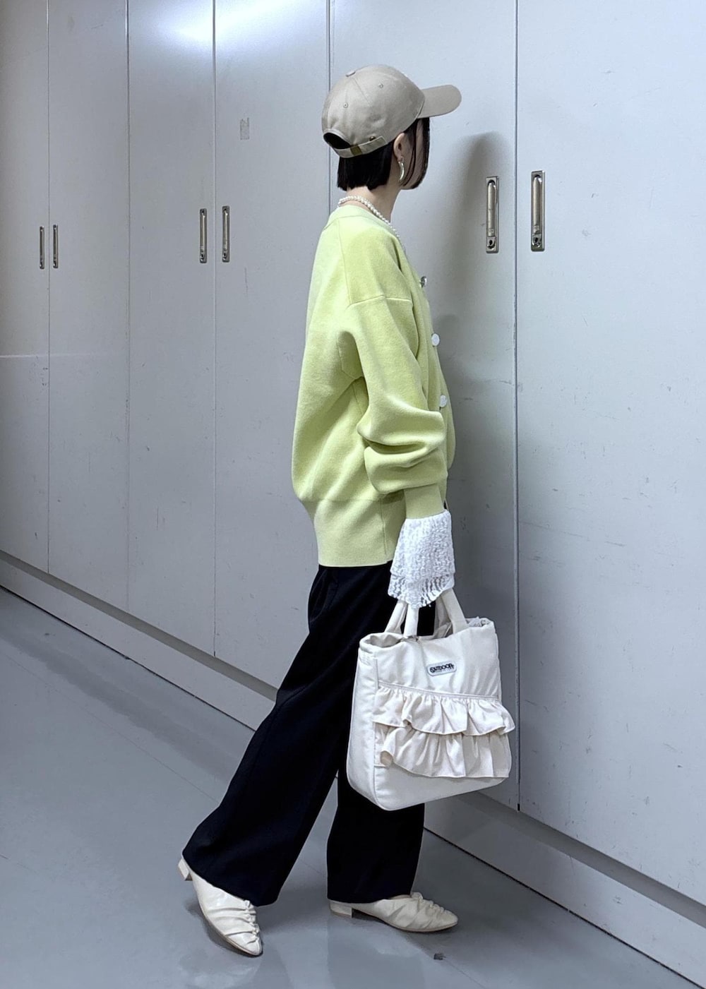 ブルー系のその他パンツ、グリーン系のカーディガン/ボレロ、ホワイト系のトートバッグを着用したレディースの冬コーディネートの2枚目の写真