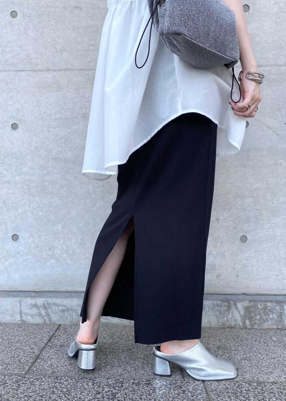 シルバー系のその他シューズ、シルバー系のショルダーバッグ、ブラック系のスカートを着用したレディースの夏コーディネートの5枚目の写真