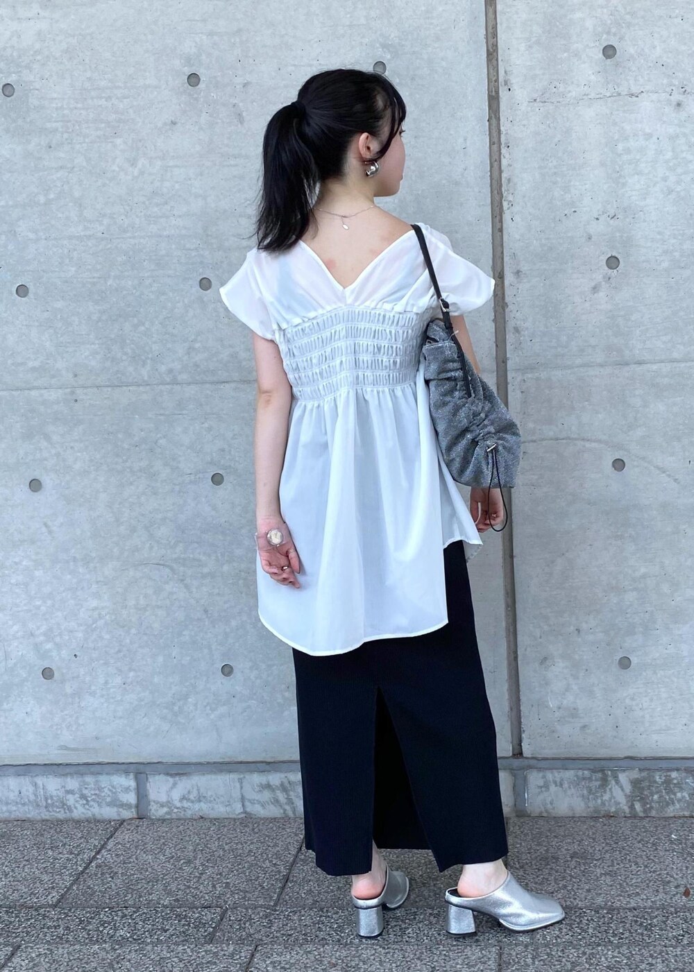 シルバー系のその他シューズ、シルバー系のショルダーバッグ、ブラック系のスカートを着用したレディースの夏コーディネートの2枚目の写真