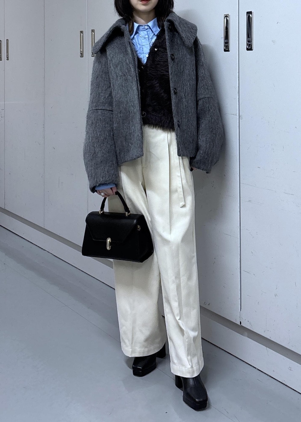 グレー系のカーディガン/ボレロ、グレー系のブルゾン、ブラック系のブーツを着用したレディースの冬コーディネートの5枚目の写真