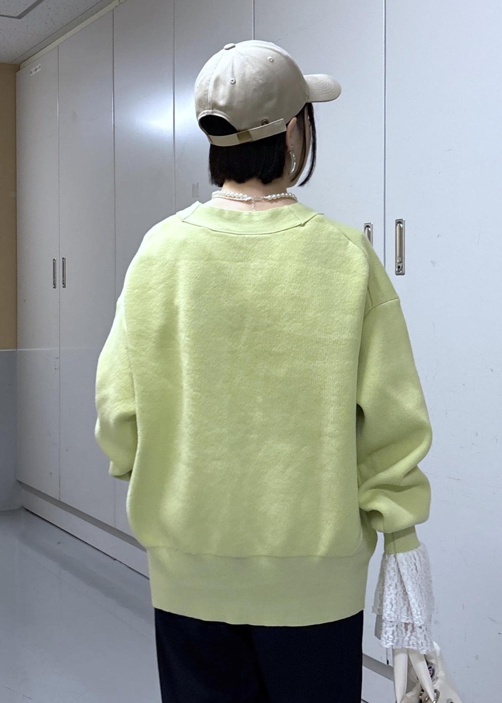 ブルー系のその他パンツ、グリーン系のカーディガン/ボレロ、ホワイト系のトートバッグを着用したレディースの冬コーディネートの7枚目の写真