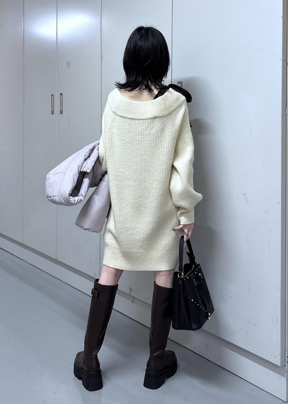 ピンク系のダウンジャケット/コート、ブラウン系のブーツ、ホワイト系のワンピースを着用したレディースの冬コーディネートの8枚目の写真