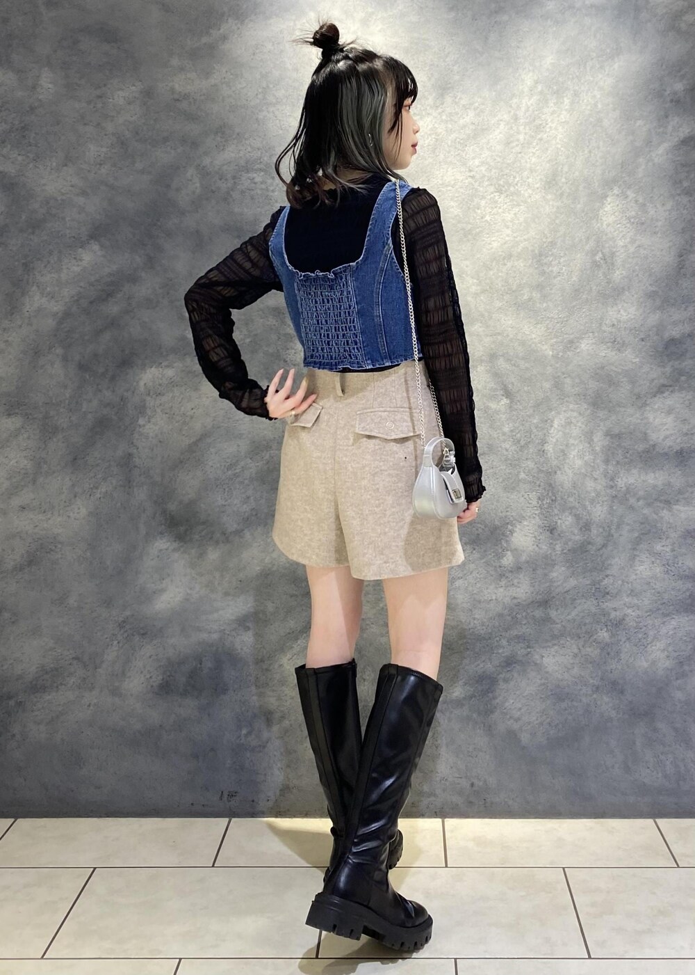 ブラック系のTシャツ/カットソー、ベージュ系のスラックス、ブルー系のベストを着用したレディースの冬コーディネートの2枚目の写真