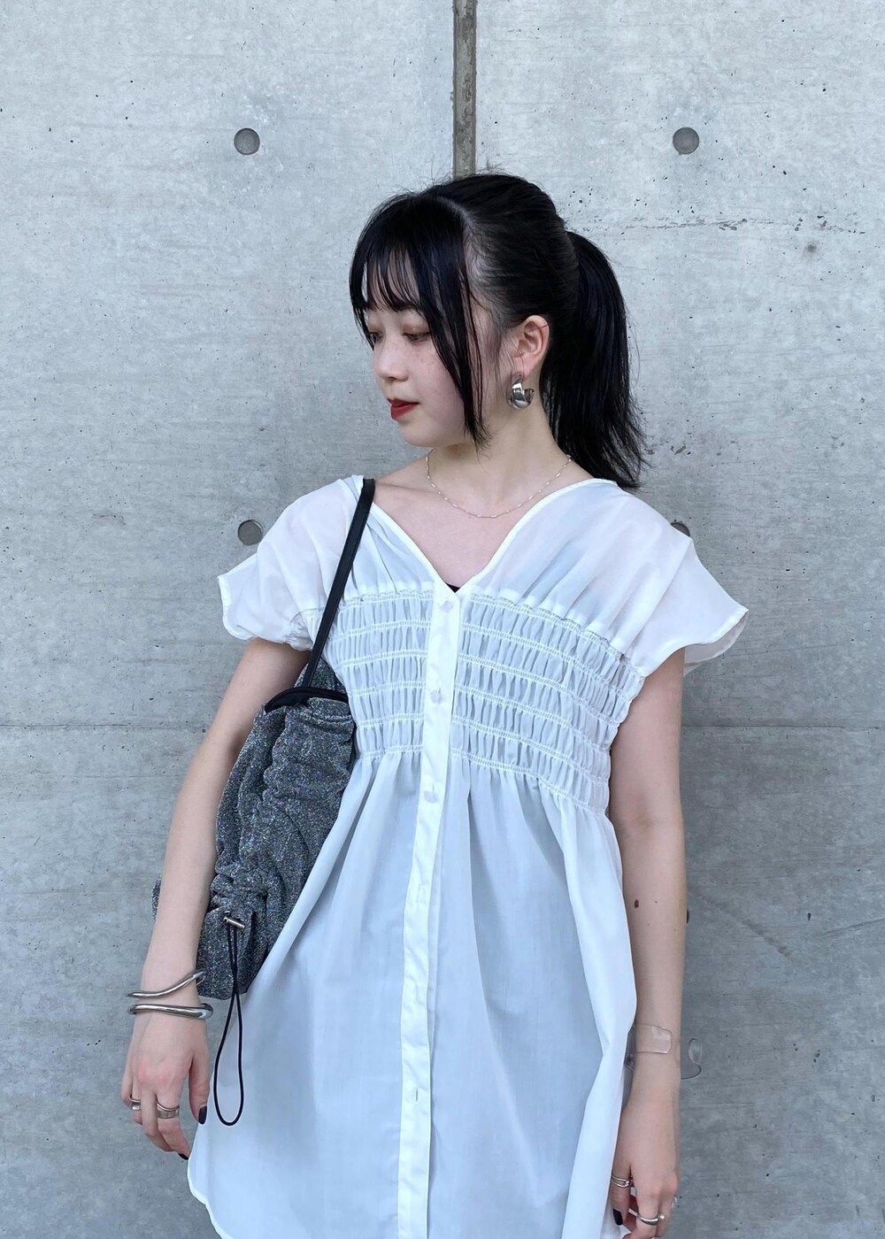 シルバー系のその他シューズ、シルバー系のショルダーバッグ、ブラック系のスカートを着用したレディースの夏コーディネートの3枚目の写真