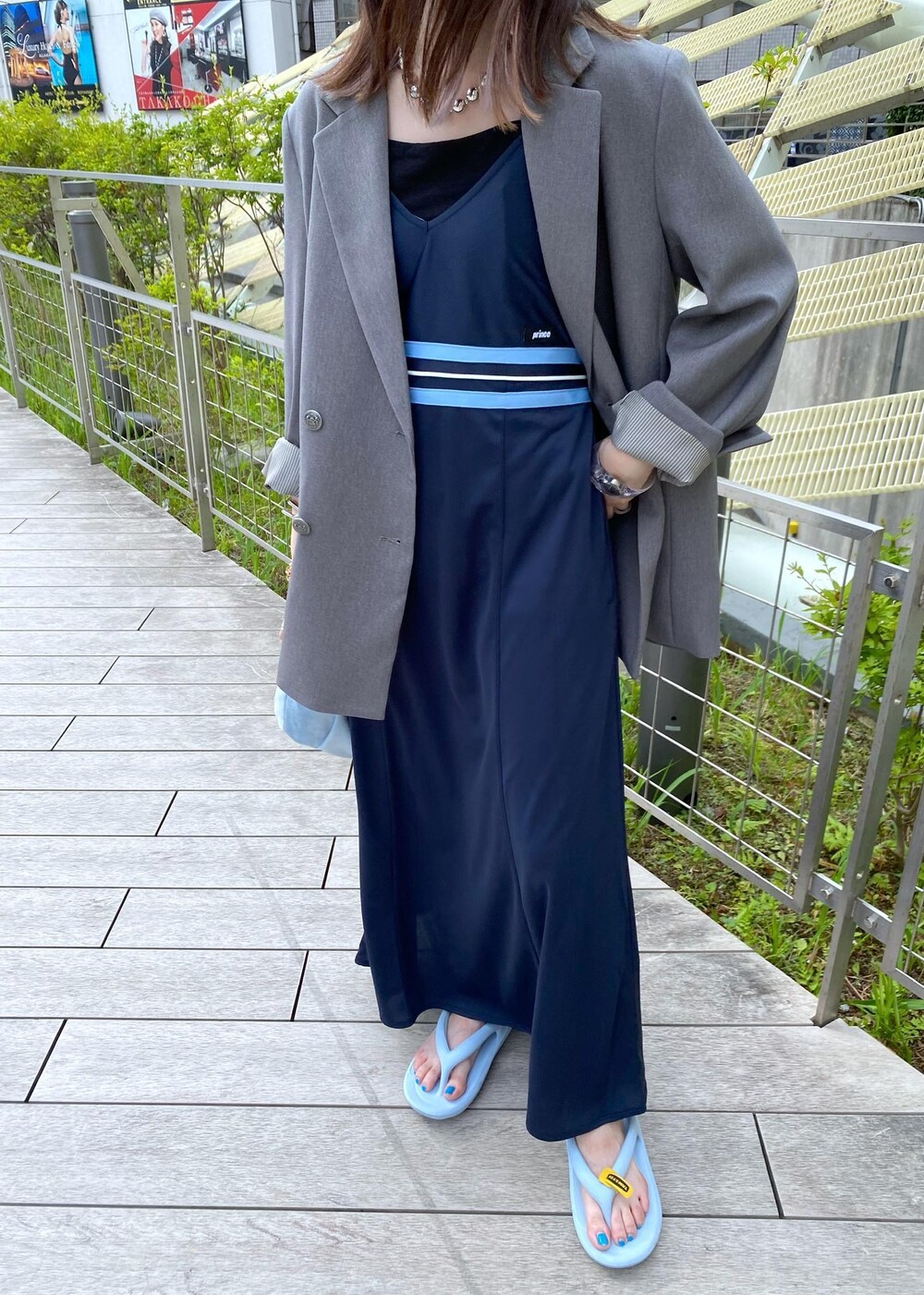 ブルー系のハンドバッグ、ブルー系のワンピース、ブルー系のサンダルを着用したレディースの夏コーディネートの6枚目の写真