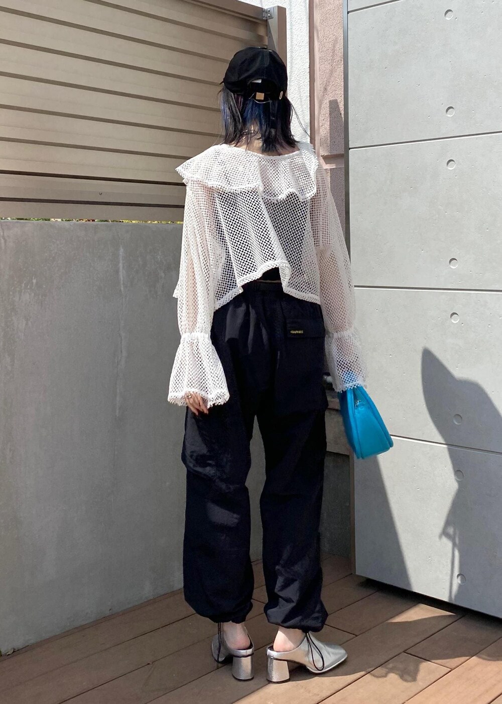 シルバー系のその他シューズ、ブラック系のカーゴパンツ、ブルー系のショルダーバッグを着用したレディースの春コーディネートの2枚目の写真