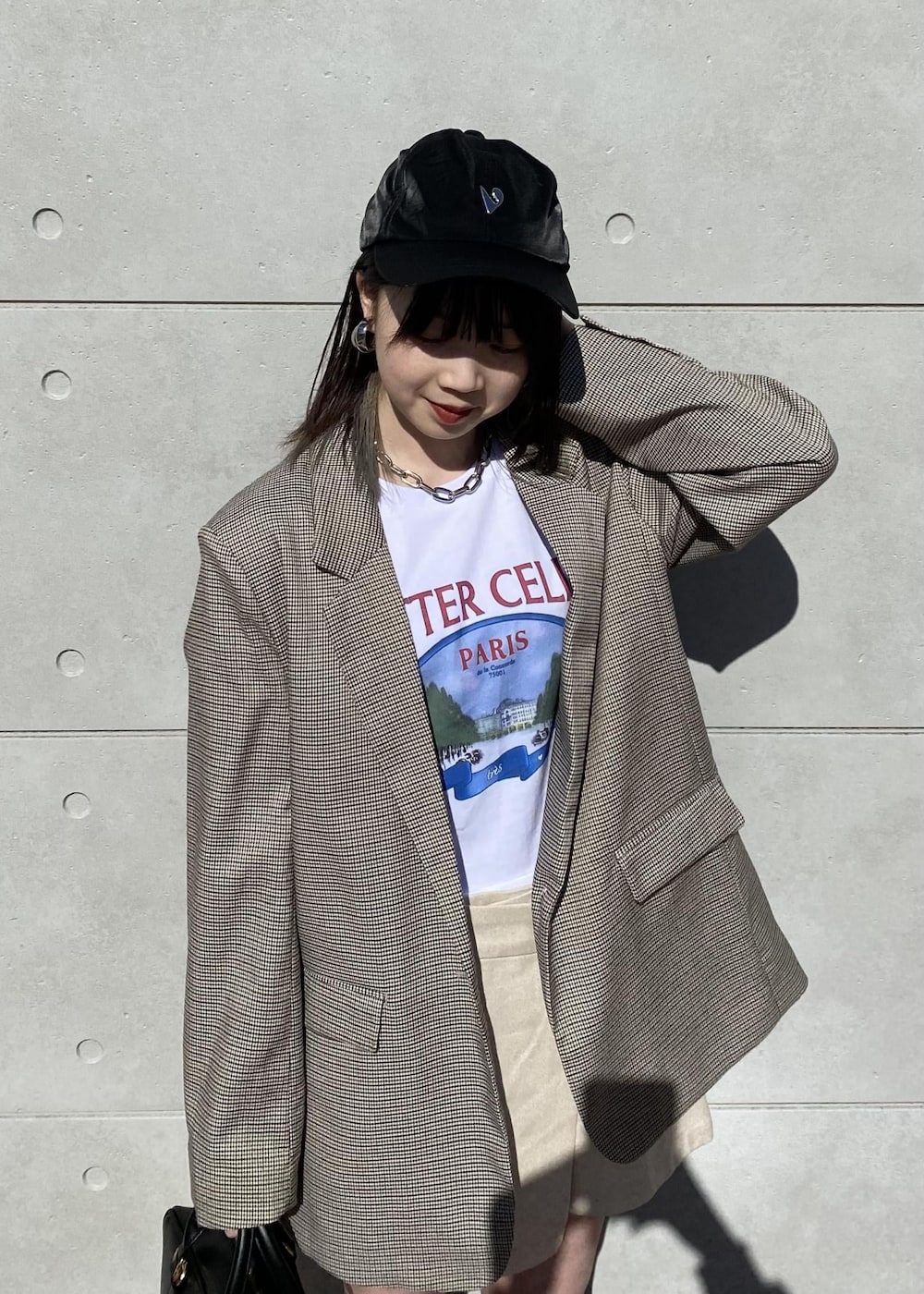 ブラウン系のテーラードジャケット、ブラック系のボストンバッグ、ベージュ系のスラックスを着用したレディースの冬コーディネートの3枚目の写真