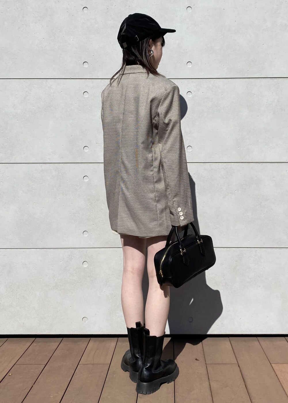 ブラウン系のテーラードジャケット、ブラック系のボストンバッグ、ベージュ系のスラックスを着用したレディースの冬コーディネートの2枚目の写真