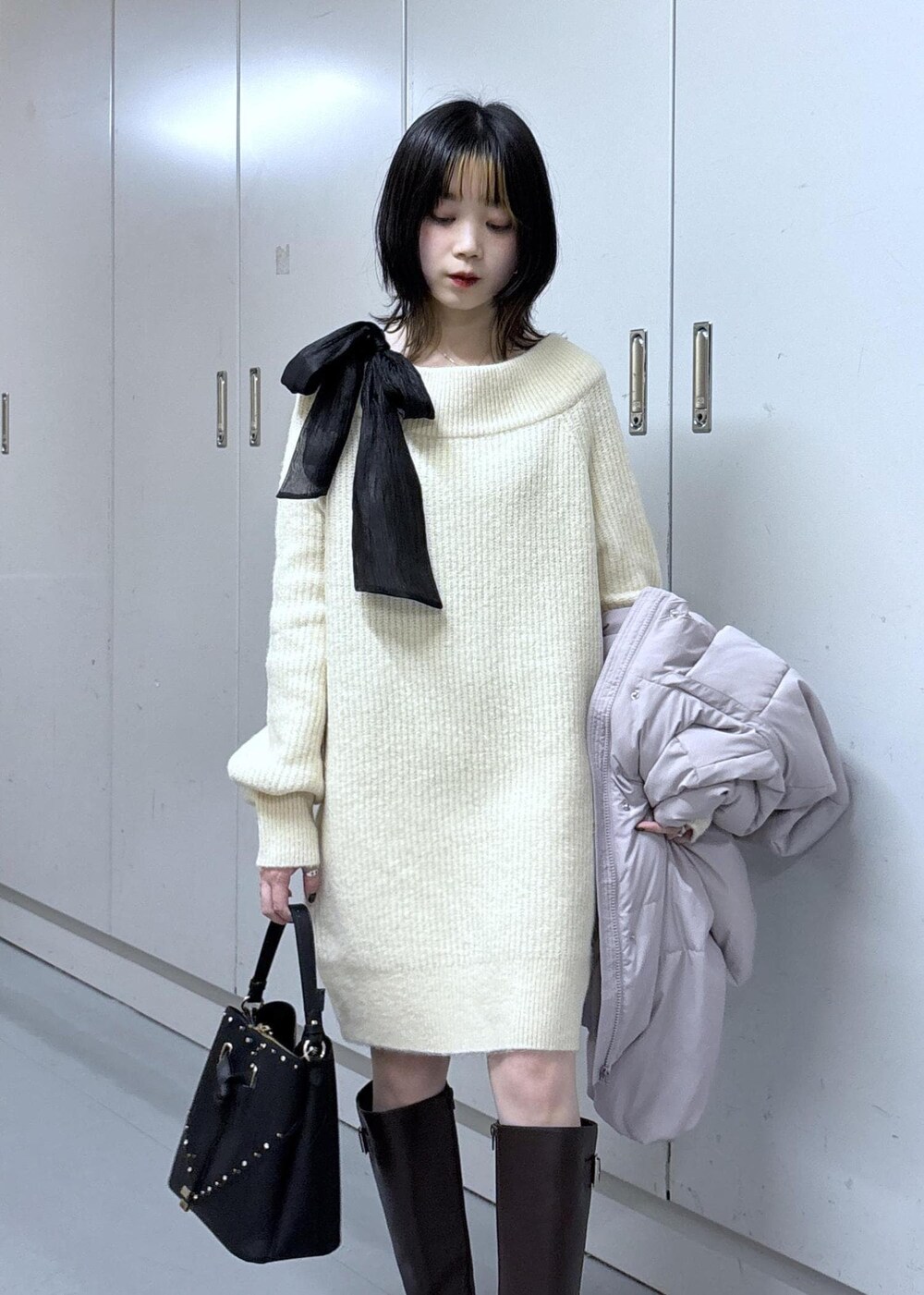 ピンク系のダウンジャケット/コート、ブラウン系のブーツ、ホワイト系のワンピースを着用したレディースの冬コーディネートの9枚目の写真