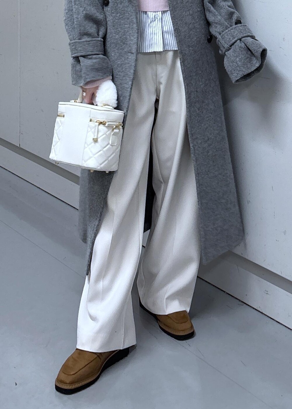 ベージュ系のローファー、グレー系のその他アウター、ホワイト系のハンドバッグを着用したレディースの冬コーディネートの6枚目の写真