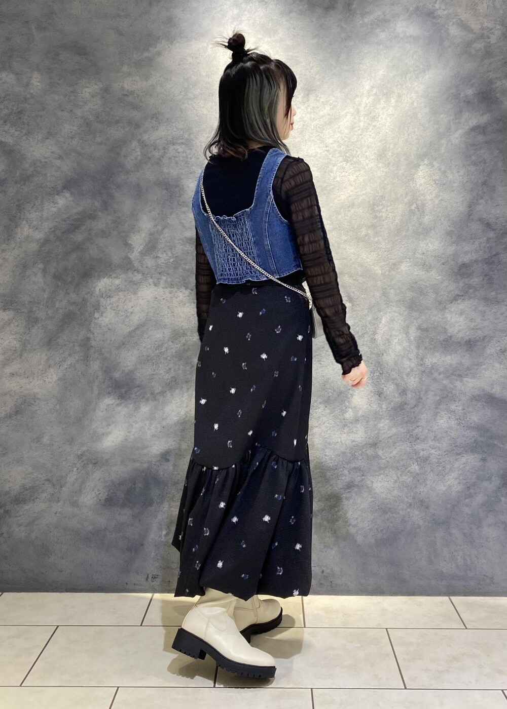 ブラック系のTシャツ/カットソー、ホワイト系のブーツ、ブルー系のベストを着用したレディースの冬コーディネートの2枚目の写真