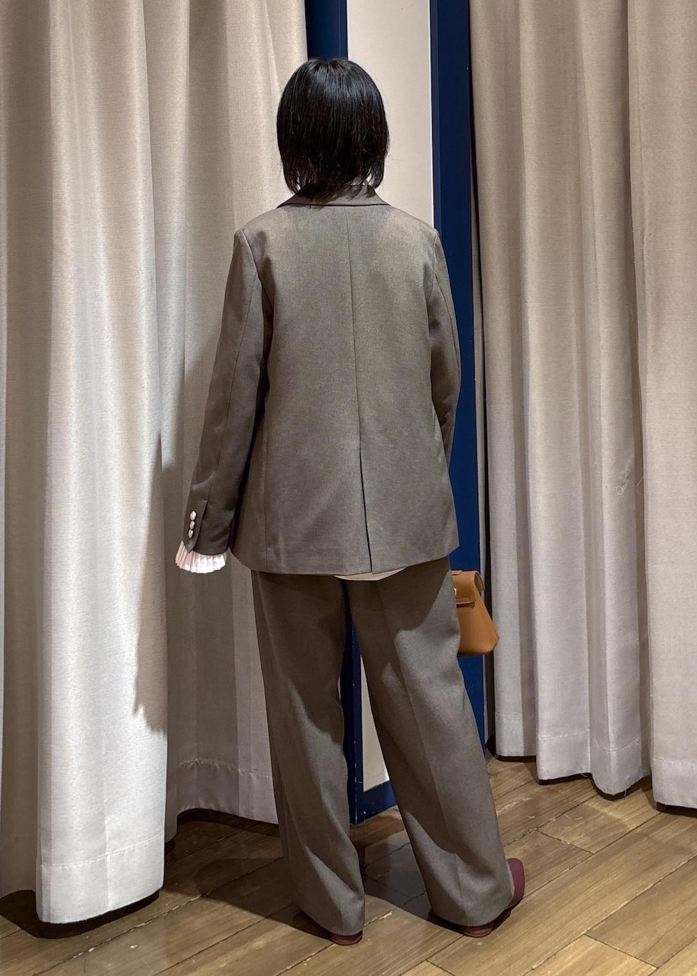 イエロー系のショルダーバッグ、レッド系のパンプス、グリーン系のテーラードジャケットを着用したレディースの秋コーディネートの5枚目の写真