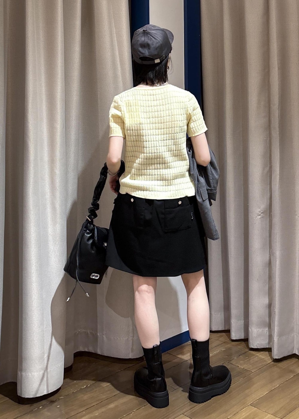 ブラック系のショルダーバッグ、ベージュ系のカーディガン/ボレロ、ブラック系のテーラードジャケットを着用したレディースの秋コーディネートの6枚目の写真