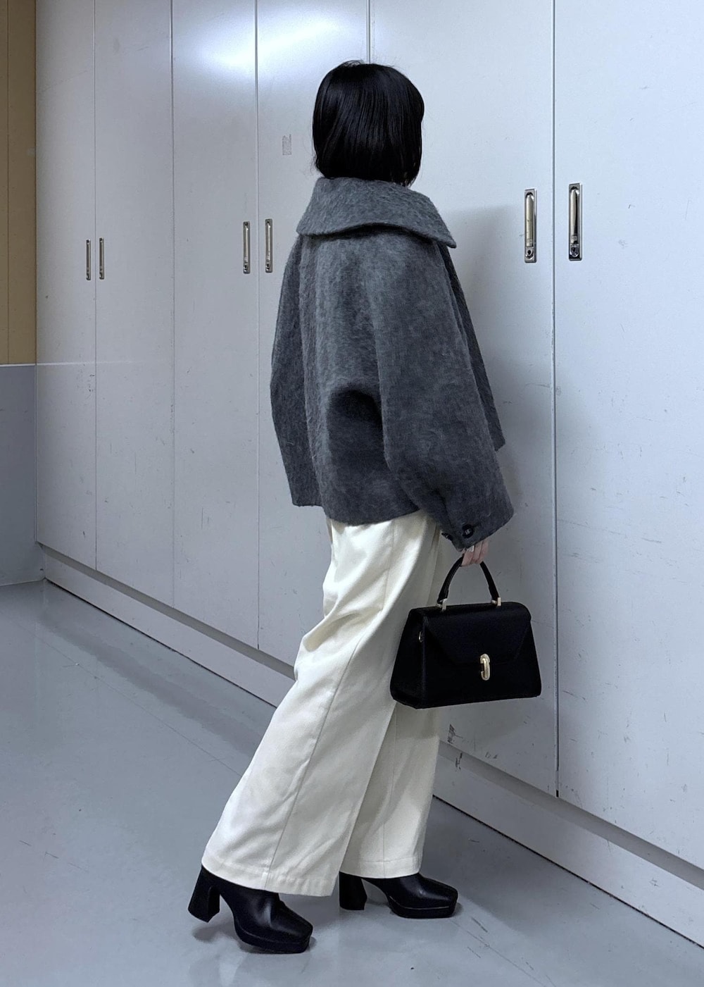 グレー系のカーディガン/ボレロ、グレー系のブルゾン、ブラック系のブーツを着用したレディースの冬コーディネートの3枚目の写真