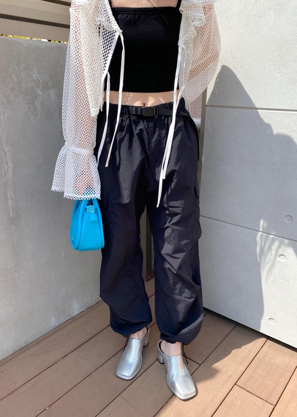 シルバー系のその他シューズ、ブラック系のカーゴパンツ、ブルー系のショルダーバッグを着用したレディースの春コーディネートの4枚目の写真