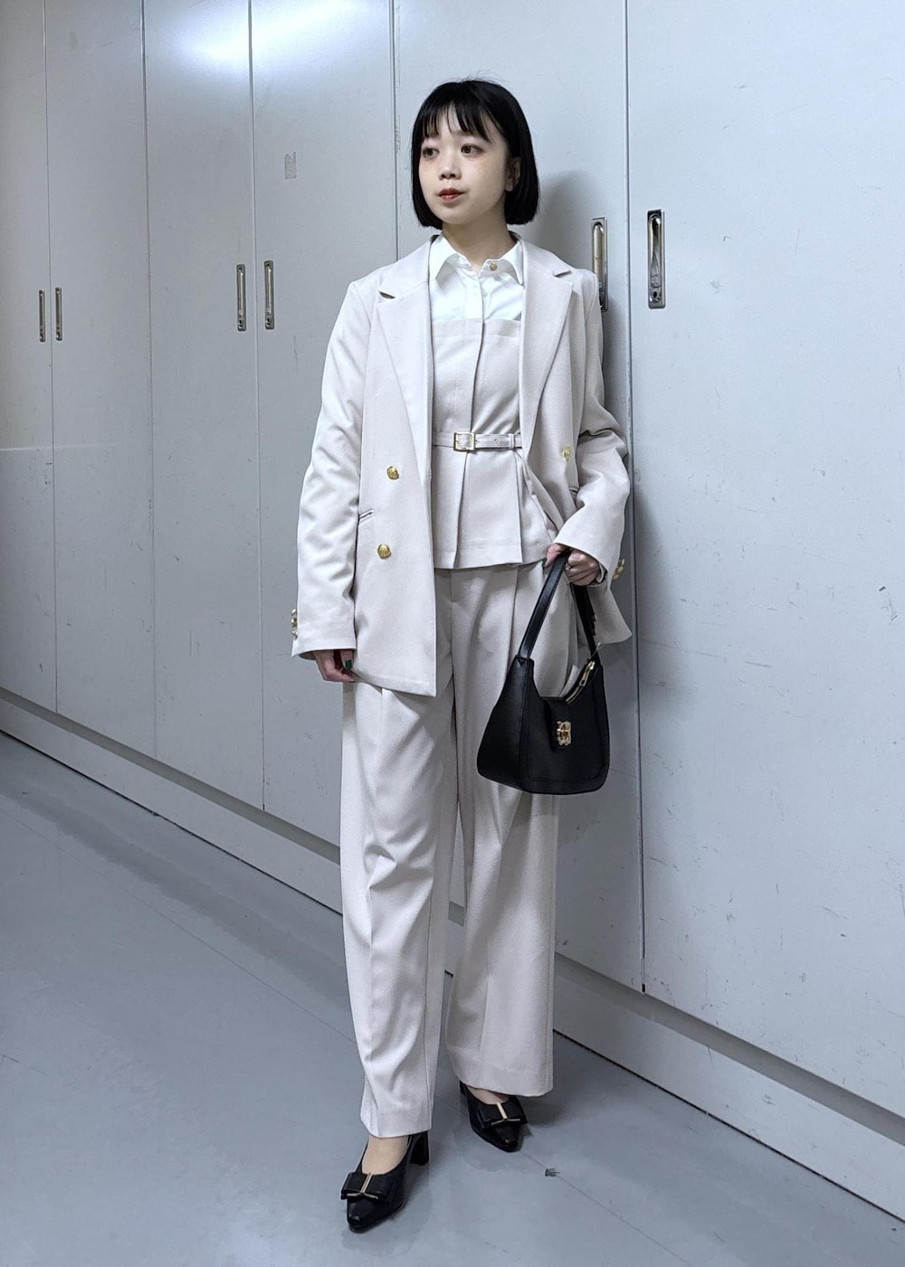 ブラック系のショルダーバッグ、ブラック系のパンプス、ベージュ系のその他パンツを着用したレディースの冬コーディネートの2枚目の写真