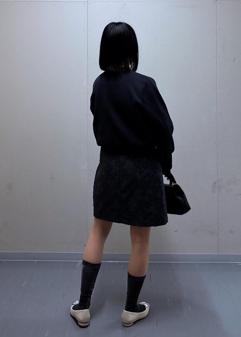 グレー系のスカート、ベージュ系のテーラードジャケット、ホワイト系のバレエシューズを着用したレディースの春コーディネートの8枚目の写真