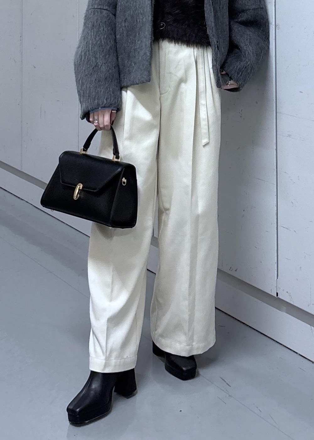 グレー系のカーディガン/ボレロ、グレー系のブルゾン、ブラック系のブーツを着用したレディースの冬コーディネートの9枚目の写真