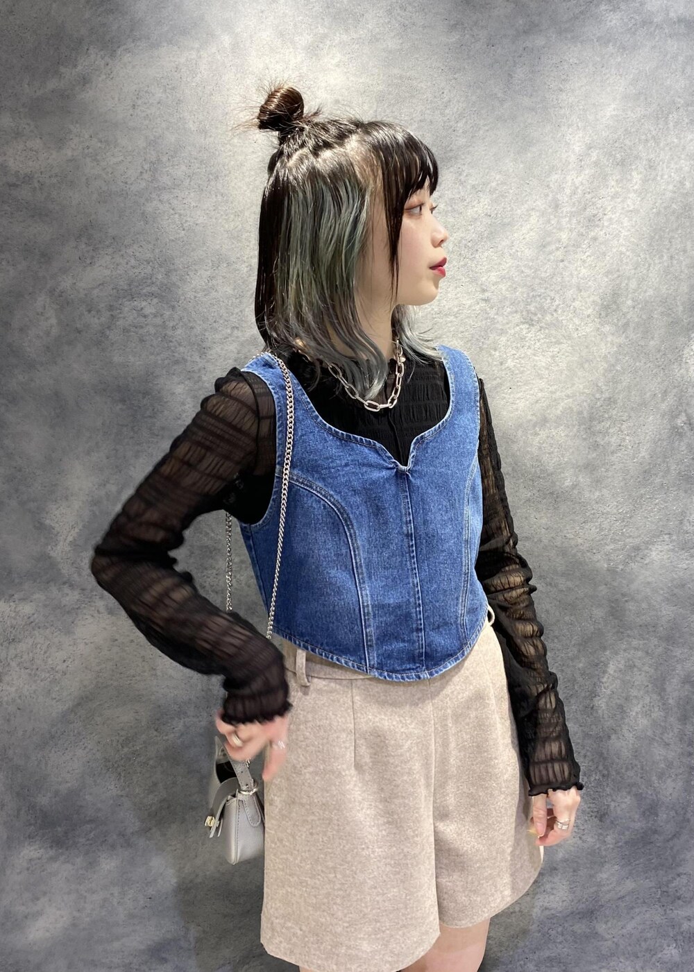 ブラック系のTシャツ/カットソー、ベージュ系のスラックス、ブルー系のベストを着用したレディースの冬コーディネートの3枚目の写真