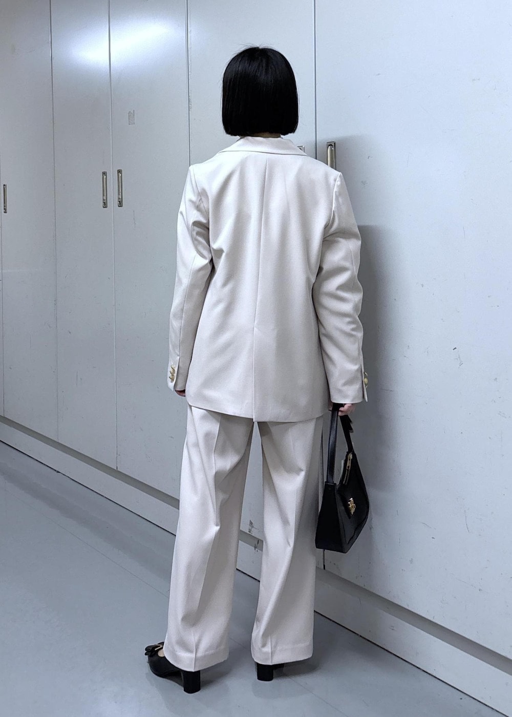 ブラック系のショルダーバッグ、ブラック系のパンプス、ベージュ系のその他パンツを着用したレディースの冬コーディネートの4枚目の写真