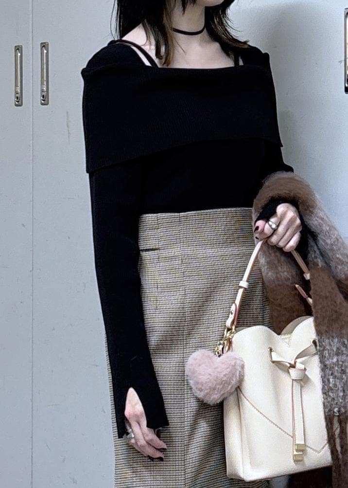 ベージュ系のショルダーバッグ、ベージュ系のスカート、ブラック系のニット/セーターを着用したレディースの冬コーディネートの6枚目の写真